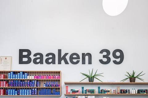Schriftzug „Baaken 39“ an der Wand über den Regalen mit Aveda-Produkten
